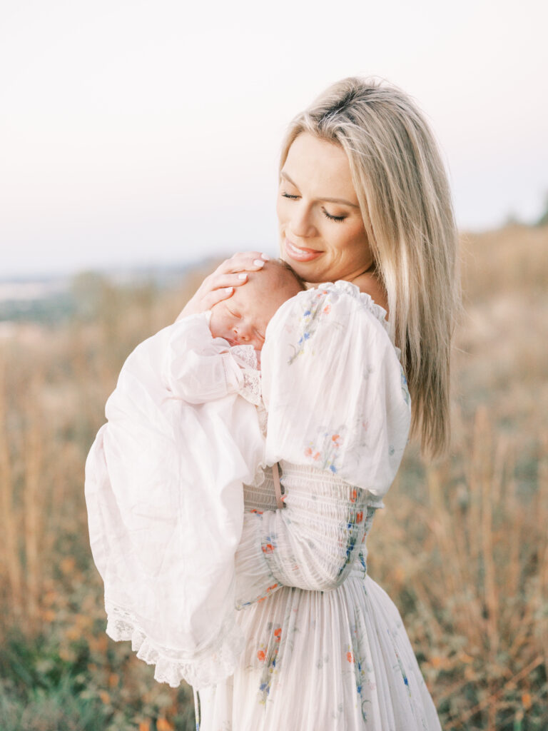 Mom holding newborn during a fall photo shoot in Birmingham, Alabama