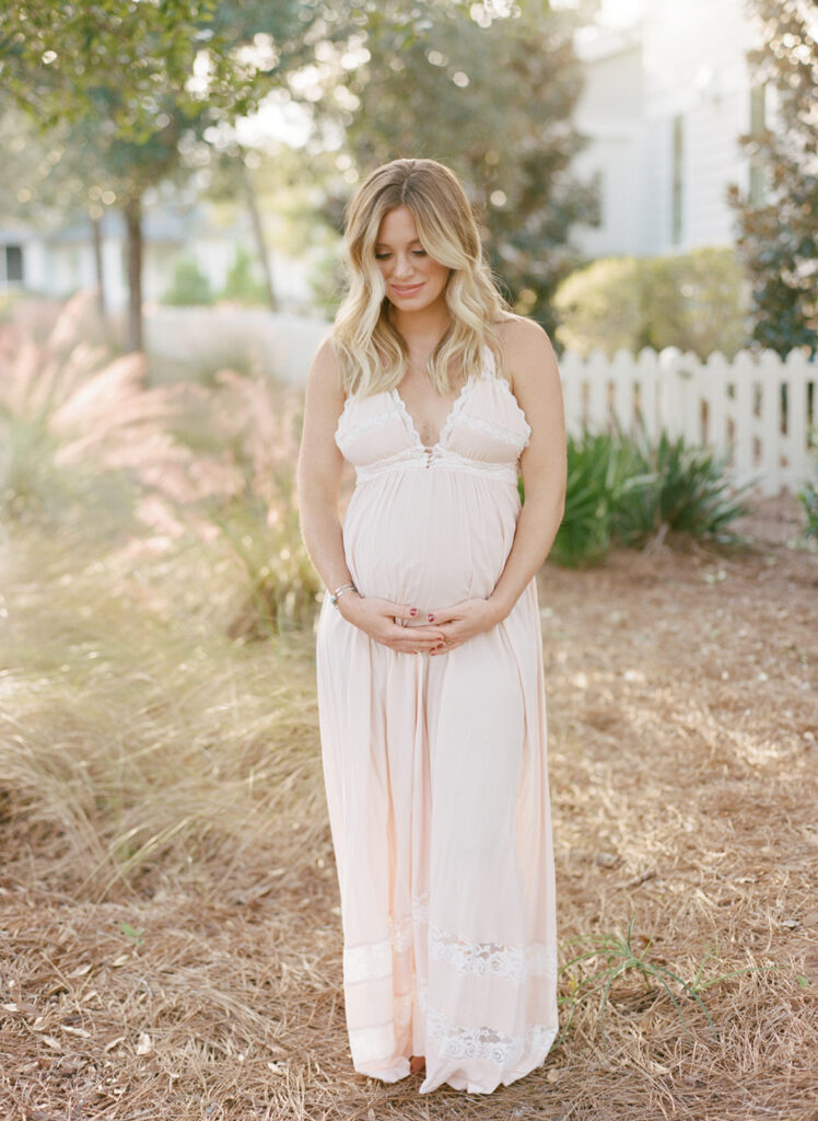 Pregnant woman holding belly during outdoor maternity session in Birmingham