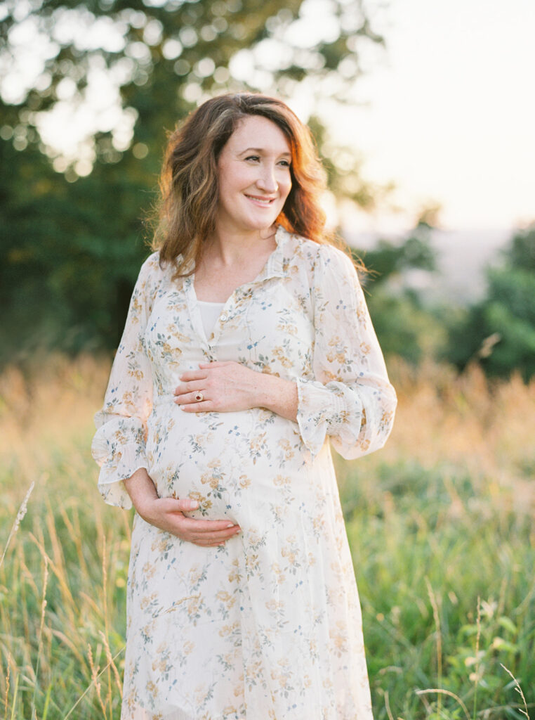 Pregnant woman holding belly during outdoor maternity session
