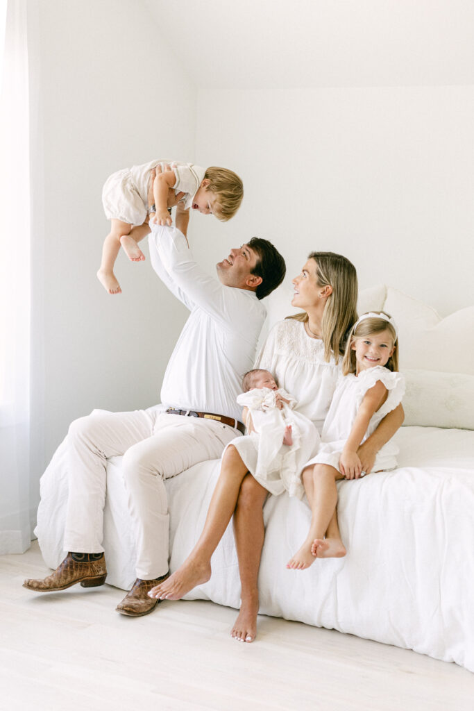 Parents smiling at their newborn baby during a relaxed lifestyle newborn photography session.