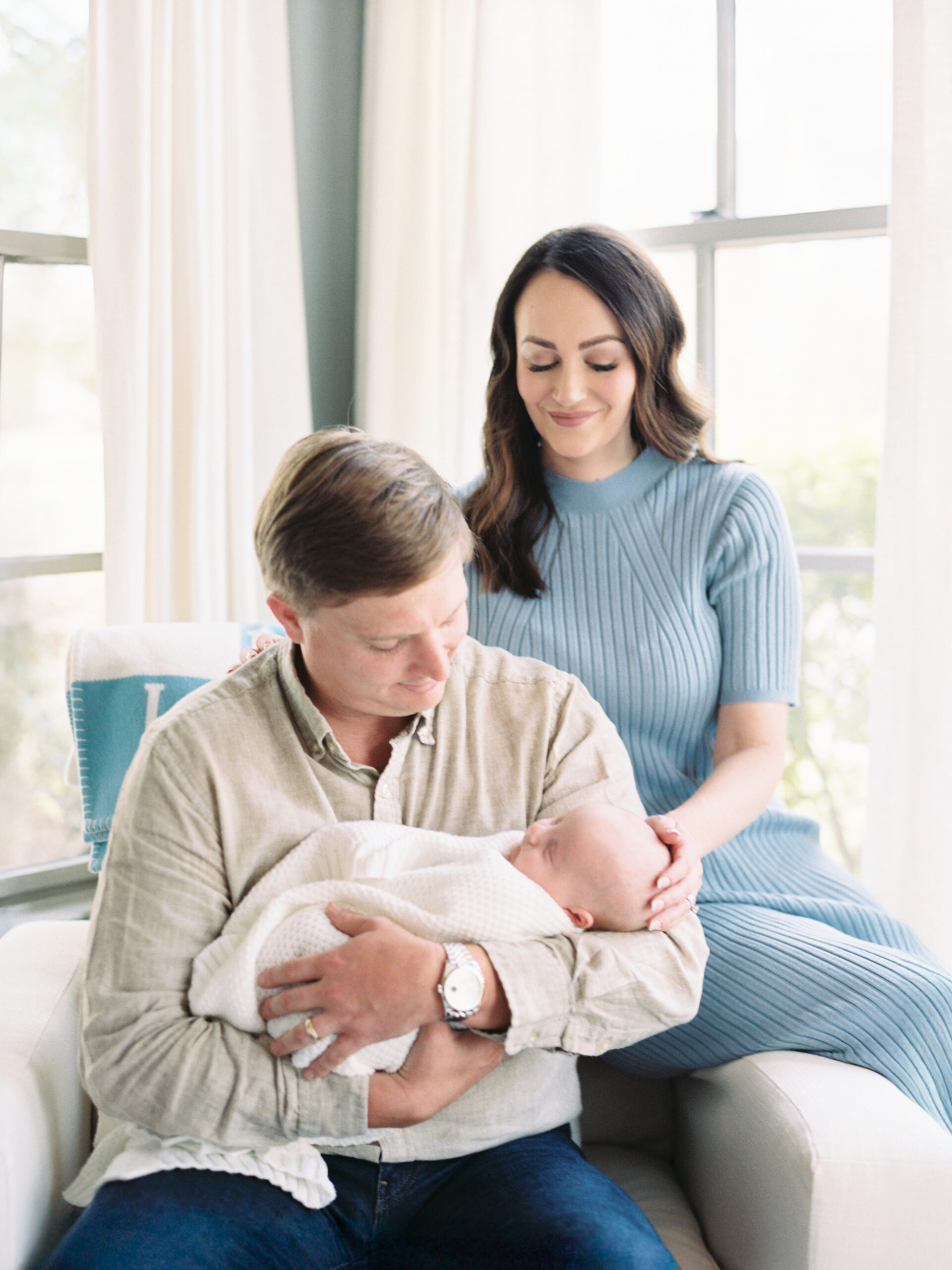 New parents holding their newborn during a lifestyle newborn photography session in Birmingham.