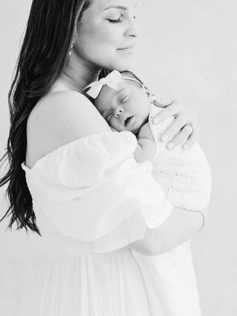 Mother holding newborn during a lifestyle newborn photography session in Birmingham.