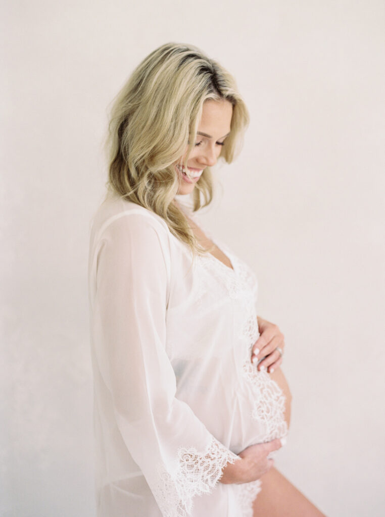 Expecting mother in a soft, neutral dress photographed during a calm maternity session in Birmingham, Alabama.