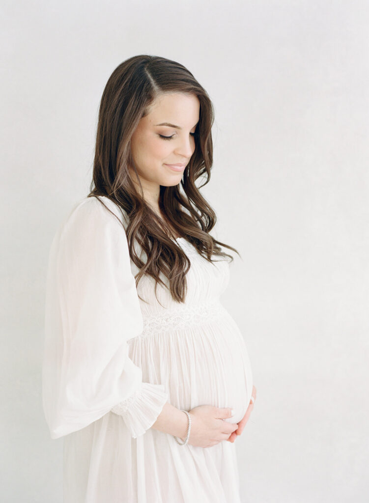 Pregnant mother in a flowing neutral gown during a luxury maternity photography session in Birmingham, Alabama.