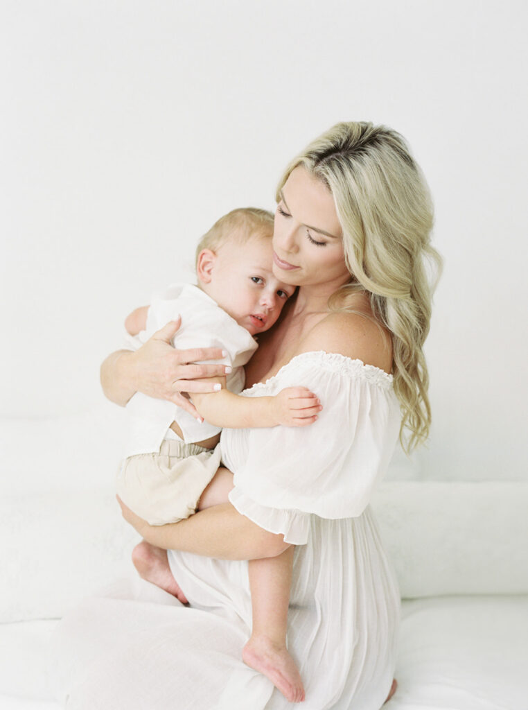 Toddler embracing mother’s baby bump during a heartfelt maternity photography session.